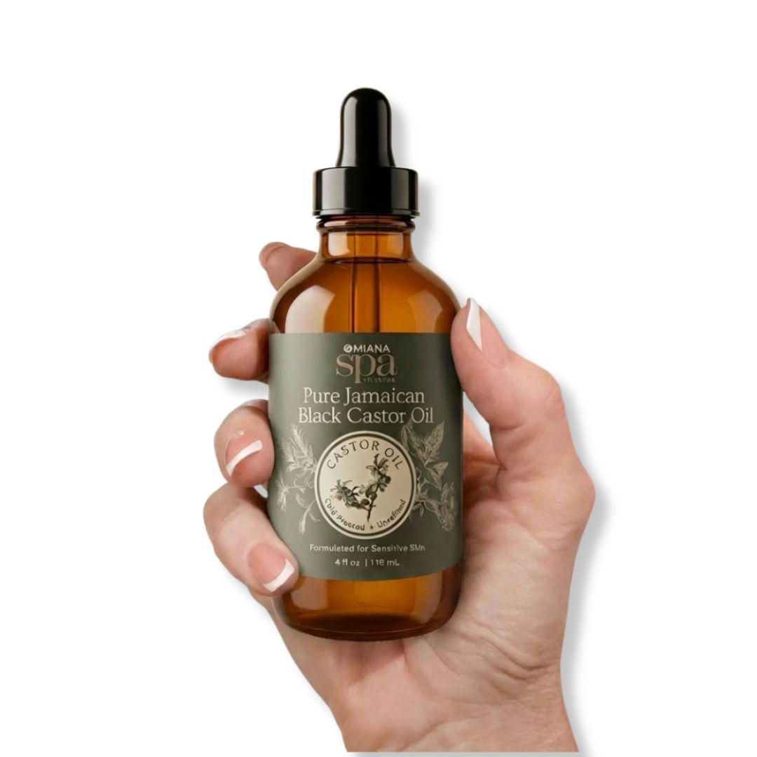 Hand holding a bottle of Pure Jamaican Black Castor Oil with a visible label | Omiana Spa